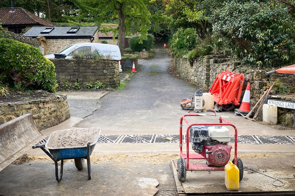 View looking up Bonnings Lane in Barrington of newly completed silt trap with with builders' equipment including a wheelbarrow, generator and pick-axes.