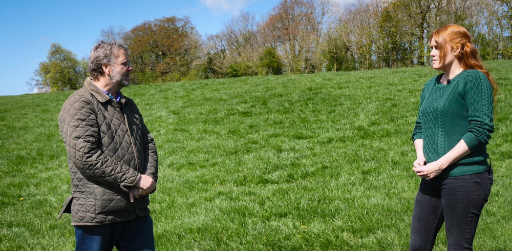 John Rowlands and Shelly Easton stood socially-distanced on a grassy hillside near Wedmore with trees at the top.